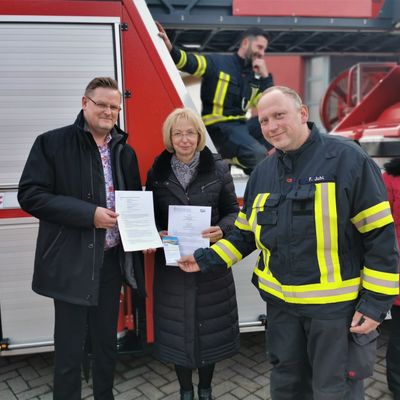 Freuen sich, dass das Gesundheitsmanagement nun auch für die Feuerwehren auf den Weg gebracht werden konnte v.l.: Dezernent Oliver Karte und Sabine Wendler mit dem LuckyFitness-Vertrag und Stadtwehrleiter Frank Juhl mit einer 10er Karte für das Rollib